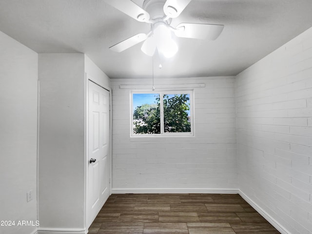 spare room featuring ceiling fan and dark wood-type flooring