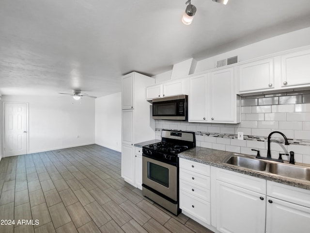 kitchen with appliances with stainless steel finishes, ceiling fan, sink, backsplash, and white cabinetry