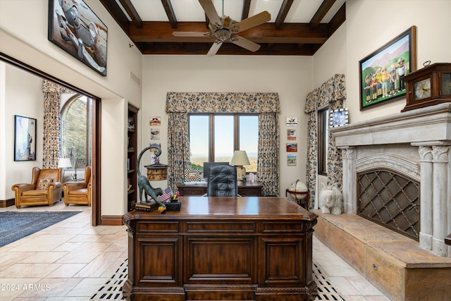 office area featuring a premium fireplace, beam ceiling, ceiling fan, and a wealth of natural light