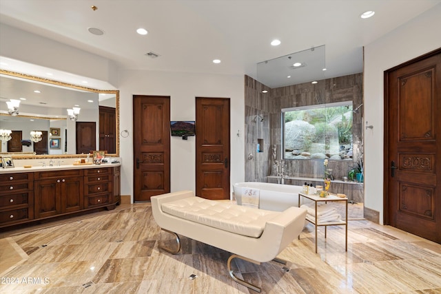 bathroom with vanity, separate shower and tub, and a notable chandelier