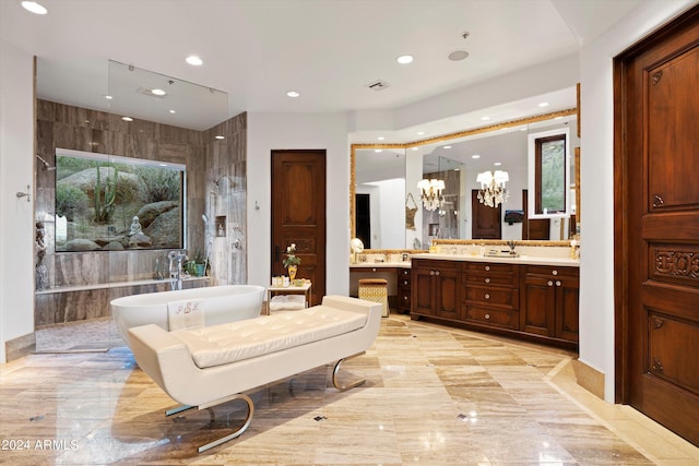 bathroom with plenty of natural light, a tub to relax in, a chandelier, and vanity