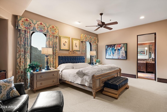 bedroom with sink, ensuite bathroom, ceiling fan, and light colored carpet