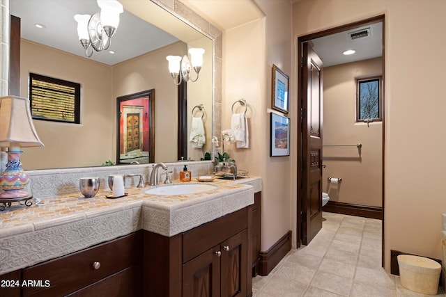 bathroom featuring vanity, a chandelier, and toilet