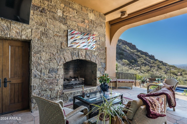 view of patio / terrace featuring an outdoor stone fireplace and a mountain view