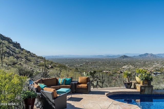 view of pool featuring outdoor lounge area, a mountain view, and a patio area