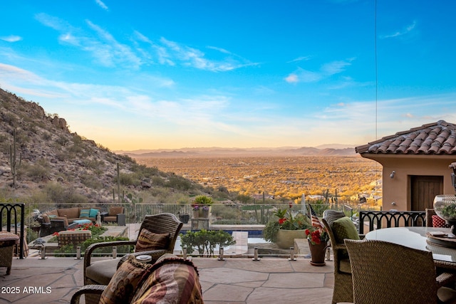 patio terrace at dusk with a mountain view and outdoor lounge area