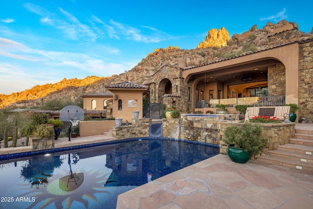 view of swimming pool with a patio area and a mountain view