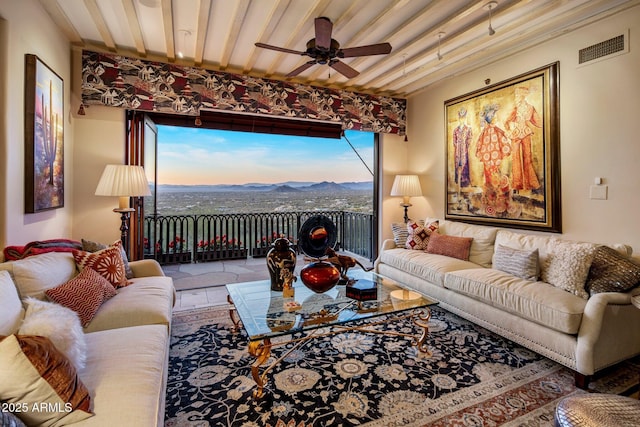 living room featuring ceiling fan and a mountain view