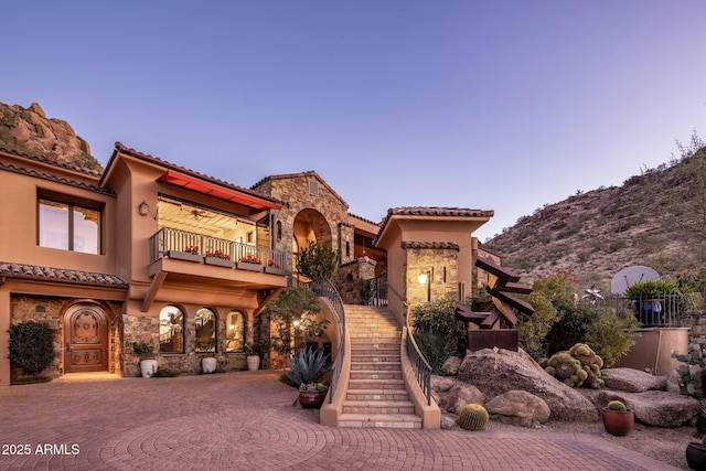 view of front of house with a balcony and a mountain view