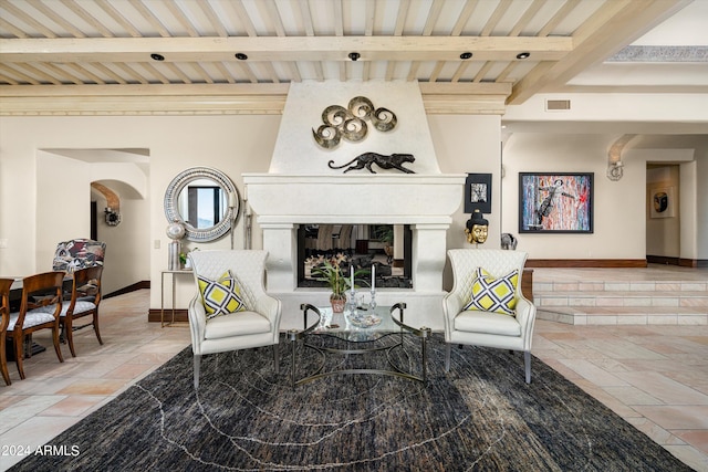 sitting room featuring a large fireplace and beamed ceiling