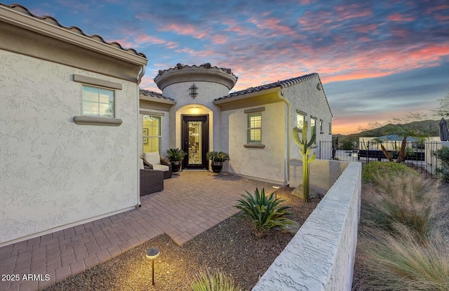 exterior entry at dusk with a patio area