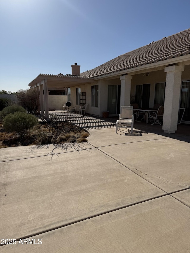 12955 E Sahuaro Dr, Scottsdale, AZ 85259 - rear view of property featuring a patio, a chimney, a tiled roof, and stucco siding