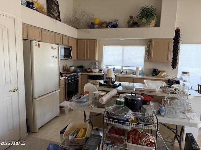 12955 E Sahuaro Dr, Scottsdale, AZ 85259 - kitchen with freestanding refrigerator, black electric range oven, stainless steel microwave, a sink, and a towering ceiling