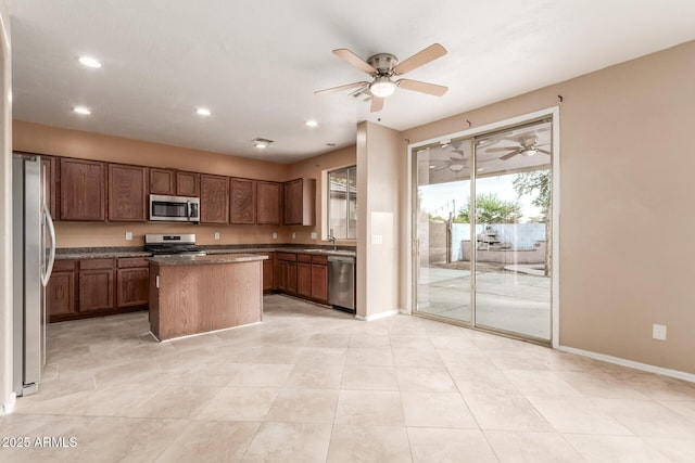 kitchen with sink, a center island, ceiling fan, and stainless steel appliances