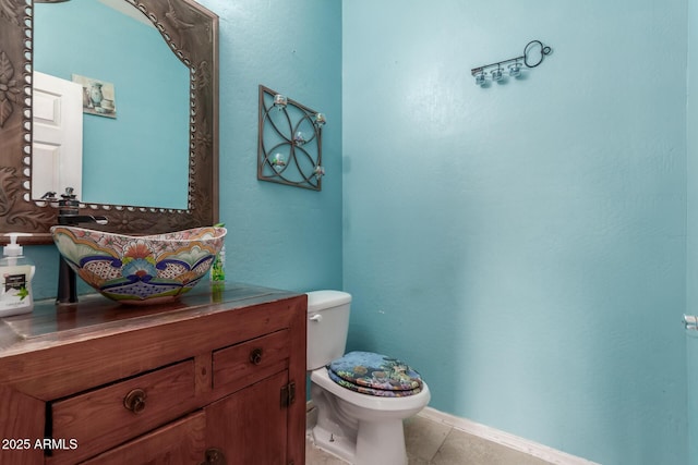 bathroom with toilet, vanity, and tile patterned flooring