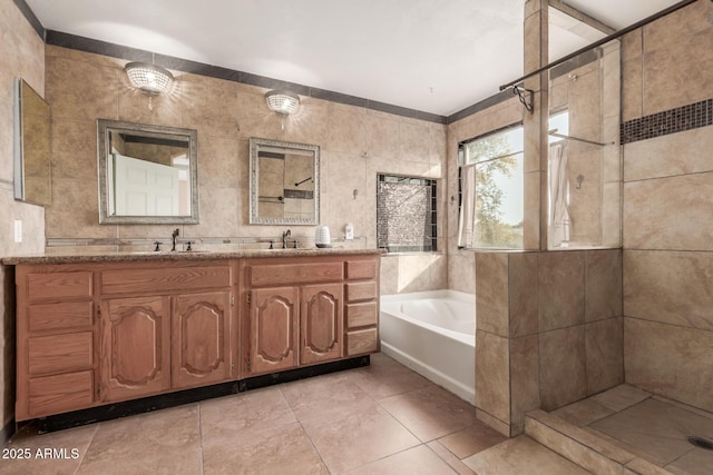 bathroom featuring vanity, shower with separate bathtub, tile walls, and tile patterned flooring