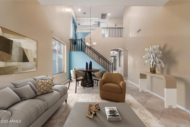 living room with a towering ceiling and light tile patterned floors