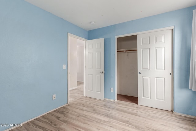 unfurnished bedroom featuring a closet and light hardwood / wood-style floors