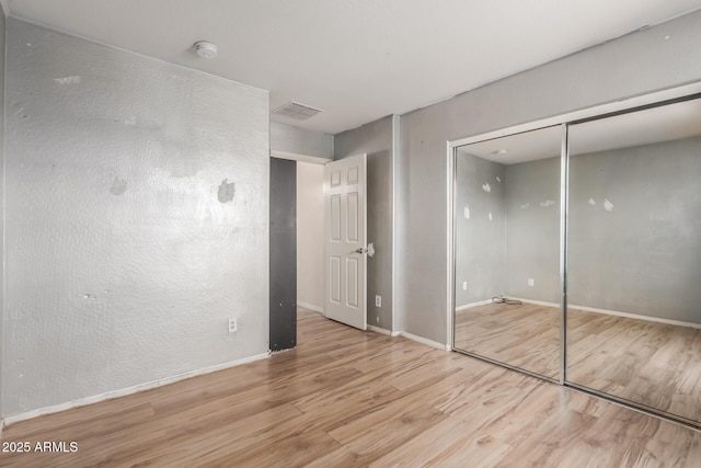 unfurnished bedroom featuring light hardwood / wood-style floors and a closet