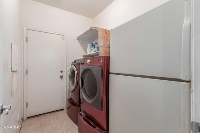 laundry area featuring washer and dryer and light tile patterned flooring