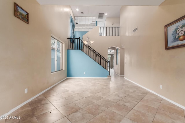 interior space featuring a notable chandelier, a high ceiling, and light tile patterned flooring