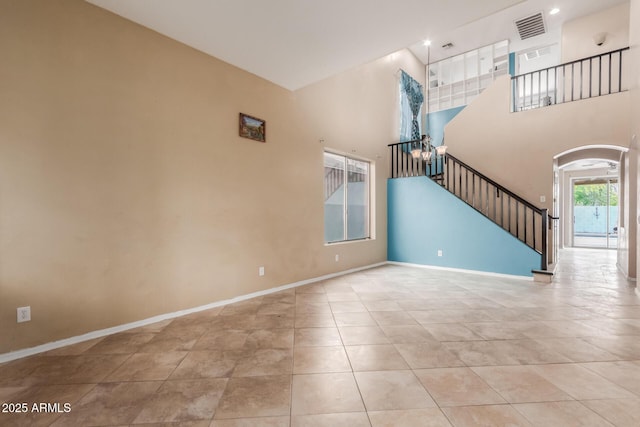 unfurnished living room featuring a high ceiling and light tile patterned floors