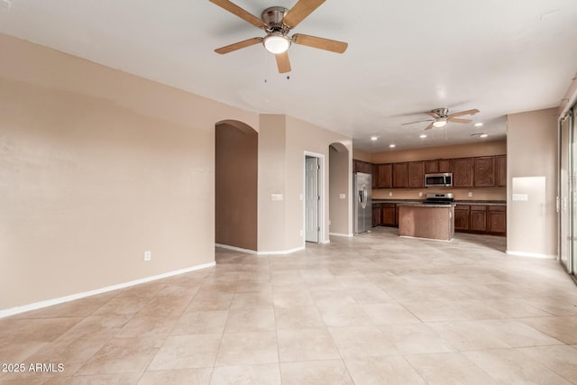 unfurnished living room featuring ceiling fan