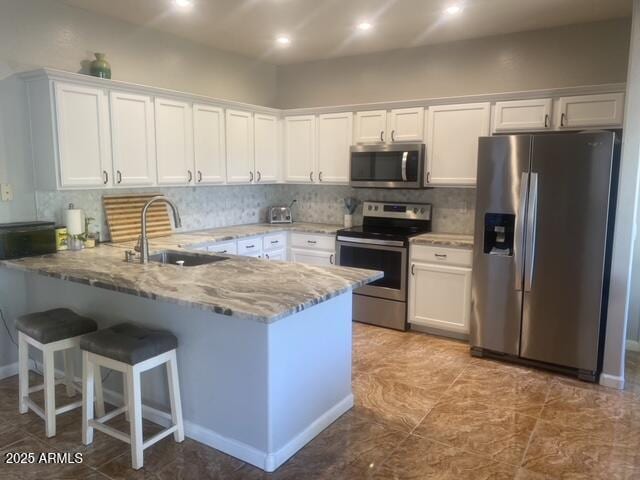 546 E San Carlos Way, Chandler, AZ 85249 - kitchen with appliances with stainless steel finishes, a sink, a peninsula, white cabinetry, and light stone countertops
