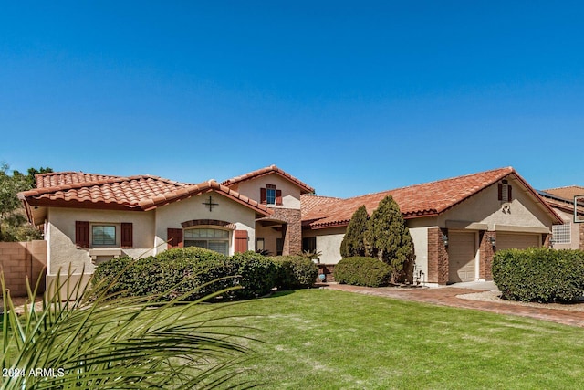 mediterranean / spanish-style home featuring a garage and a front lawn