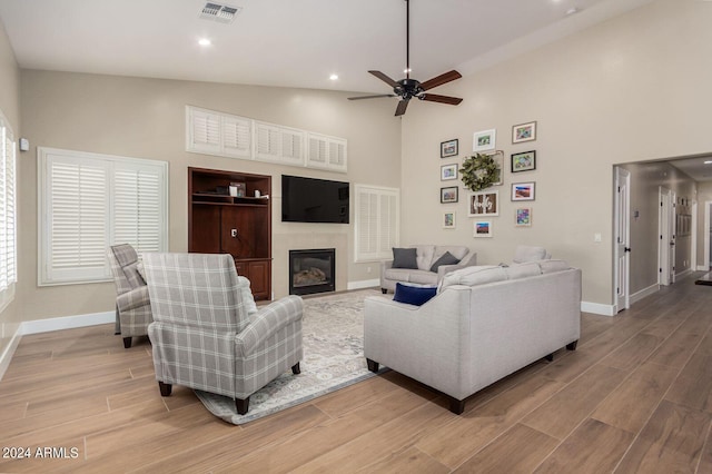 living room with a towering ceiling and ceiling fan