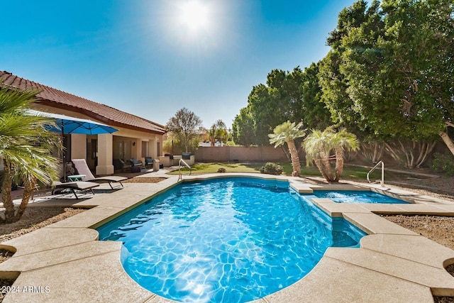 view of swimming pool featuring a patio area and an in ground hot tub