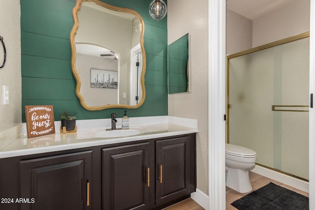 bathroom with toilet, vanity, tile patterned floors, and walk in shower