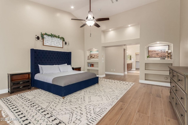 bedroom with ceiling fan, high vaulted ceiling, and light hardwood / wood-style flooring