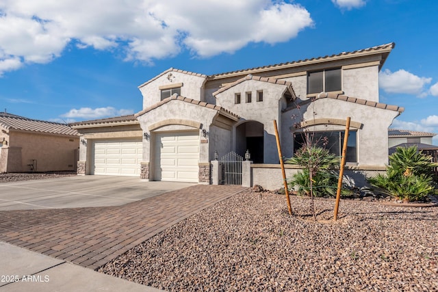 mediterranean / spanish home featuring a garage, concrete driveway, stone siding, and stucco siding