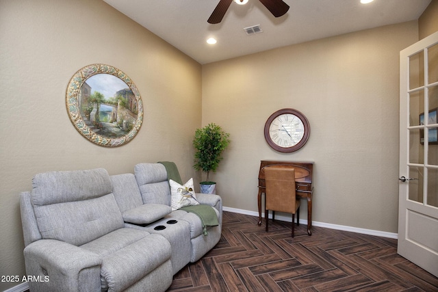 sitting room with ceiling fan and dark parquet floors