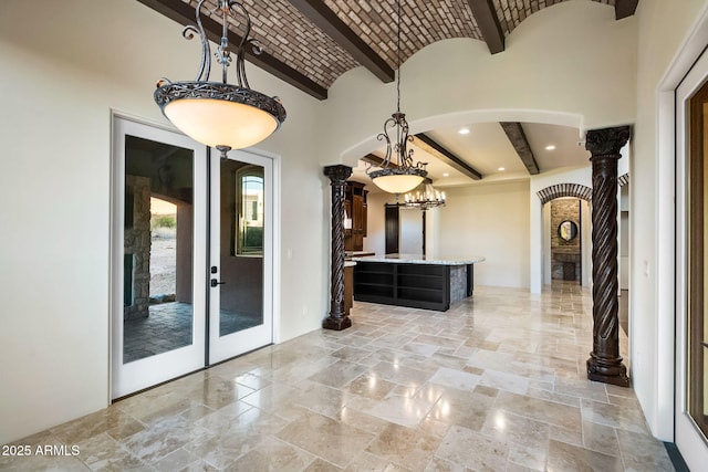 interior space featuring beamed ceiling, brick ceiling, and ornate columns