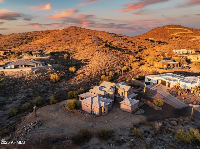 aerial view at dusk featuring a mountain view