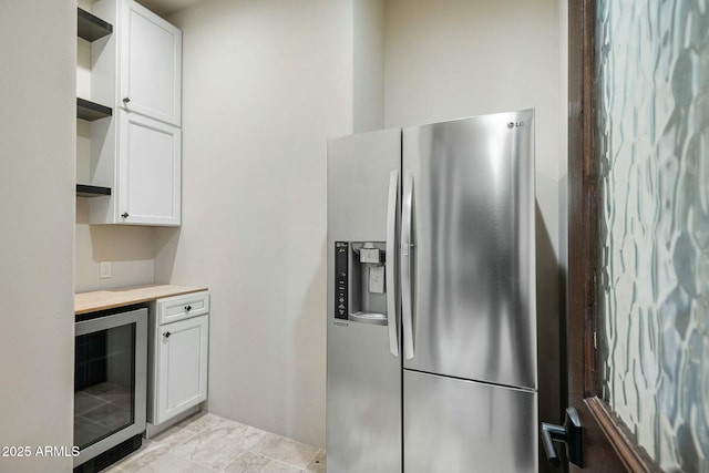 kitchen with white cabinetry, beverage cooler, and stainless steel fridge with ice dispenser