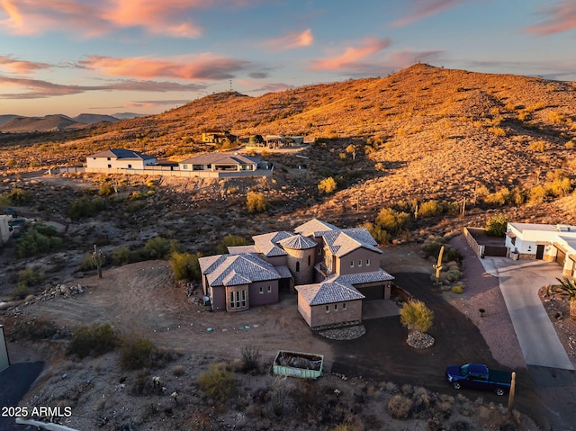 aerial view at dusk featuring a mountain view