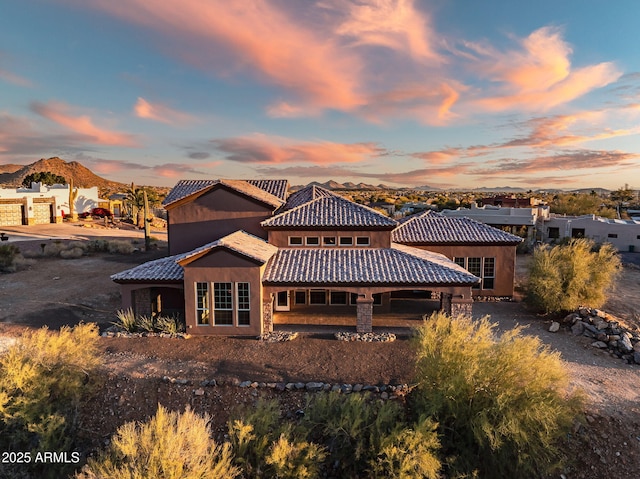 back house at dusk featuring a mountain view