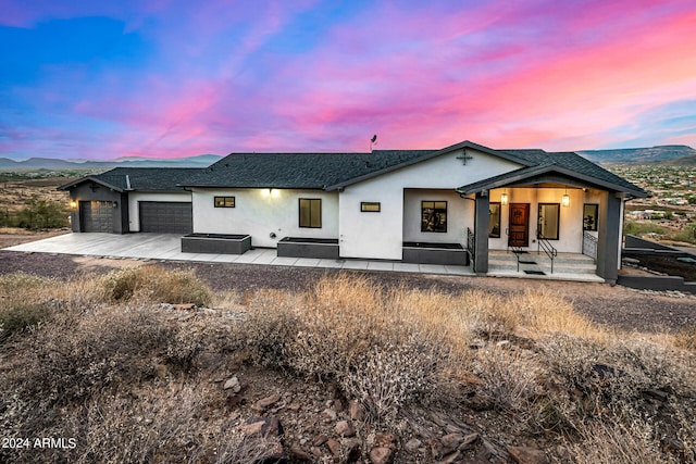 view of front of house with a mountain view, a garage, and covered porch