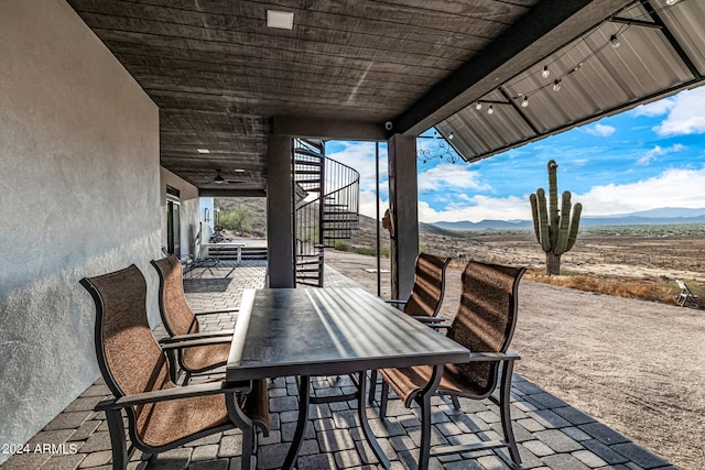 view of patio / terrace featuring ceiling fan and a mountain view