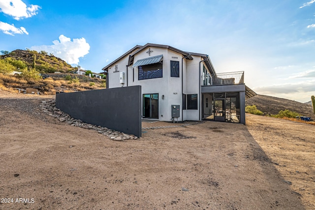 back of property with a balcony and a mountain view