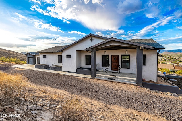 view of front of house with a patio and a mountain view