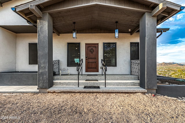 view of exterior entry featuring a mountain view and covered porch