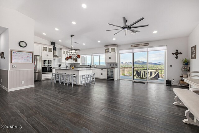 kitchen with a wealth of natural light, decorative light fixtures, stainless steel appliances, and white cabinetry