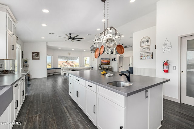 kitchen with sink, decorative light fixtures, a kitchen island with sink, dark wood-type flooring, and white cabinetry