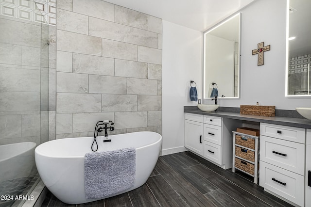 bathroom with tile walls, vanity, and a tub