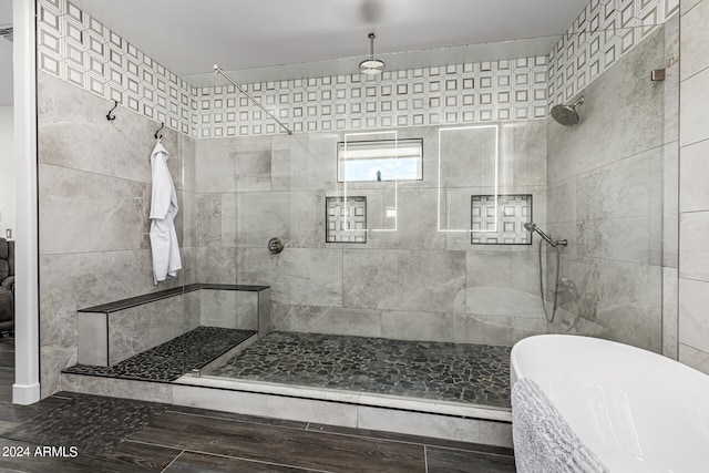 bathroom featuring independent shower and bath, tile walls, and hardwood / wood-style floors