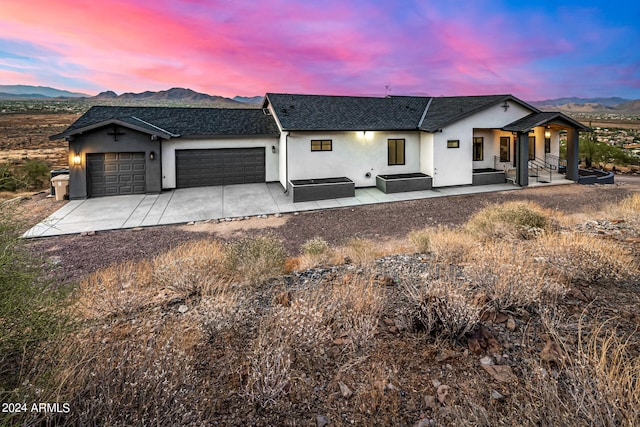 view of front of property featuring a porch, a garage, and a mountain view